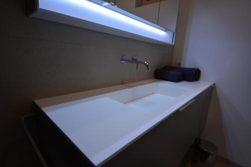 a bathroom sink with a light on top of it at wohnanders in Fürstenfeld