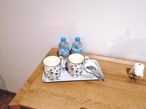 two cups on a tray with two bottles of water at La résinière in Salles