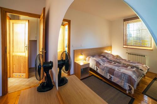 a bedroom with a bed and a fan on a table at Apartament DADAJ in Dadaj
