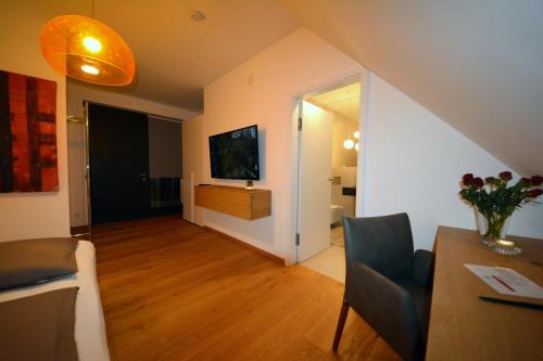 a living room with a dining table and a television at wohnanders in Fürstenfeld