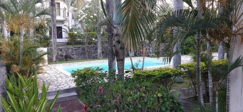 basen w ogrodzie z drzewami i roślinami w obiekcie Blue Sky Villa w mieście Grand Baie