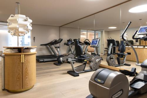 un gimnasio con cintas de correr y máquinas elípticas en AlpenGold Hotel Davos, en Davos