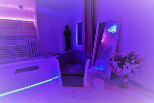 a purple room with a chair and a person in a mirror at Jacuzzi Romantique 15 min Etretat 1 in Fécamp