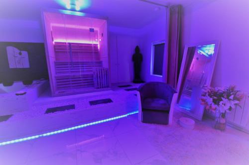 a purple room with a couch and a chair at Jacuzzi Romantique 15 min Etretat 1 in Fécamp