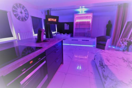 a purple room with a bed and a clock on the wall at Jacuzzi Romantique 15 min Etretat 1 in Fécamp