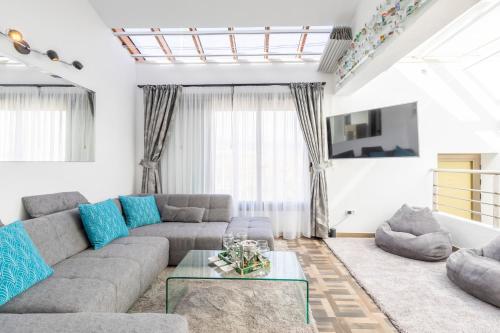 a living room with a gray couch and blue pillows at MEDANO4YOU Barefoot Beach House in El Médano