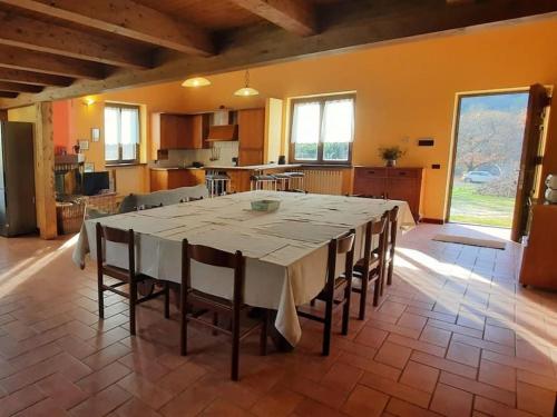 a large dining room with a table and a kitchen at Cascina Ca' Scarlatta - Your Mountain Holiday in Introbio
