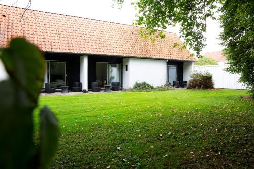 a house with a green lawn in front of it at Hotel Troense in Svendborg