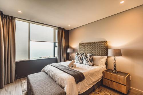 Un dormitorio con una cama y una ventana grande. en Umhlanga Arch Properties, en Durban