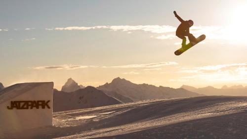 a man flying through the air while riding a snowboard at Central Sporthotel Davos in Davos