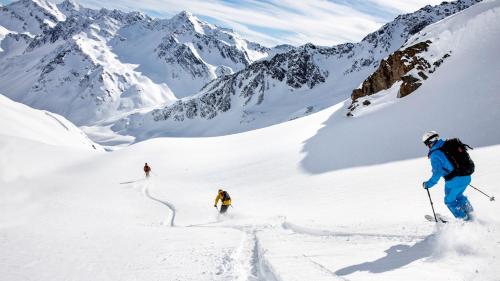 three people skiing down a snow covered mountain at Central Sporthotel Davos in Davos