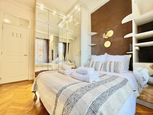 a bedroom with a large bed with towels on it at Swiss Star - Easy Home Booking in Nice