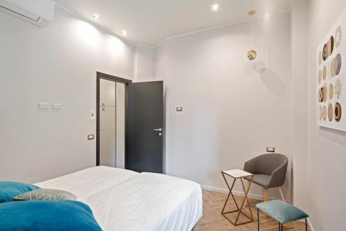 1 dormitorio blanco con 1 cama y 1 silla en MK - Apartment en Milán