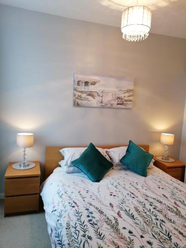 a bedroom with a bed with two night stands and two lamps at Sunrise View - Beachfront Apartment, Weymouth in Weymouth