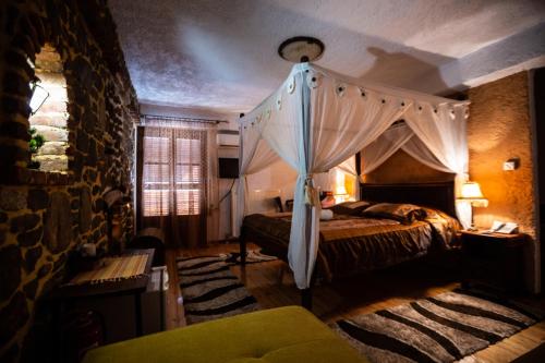 a bedroom with a canopy bed and a window at La Moara Boutique Hotel in Kraniá