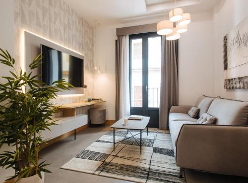 Guadalupe 15 by Magno Apartments في إشبيلية: غرفة معيشة مع أريكة وطاولة