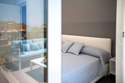 a bedroom with a bed and a couch and a window at B&B Ligure Rooms in Pietra Ligure