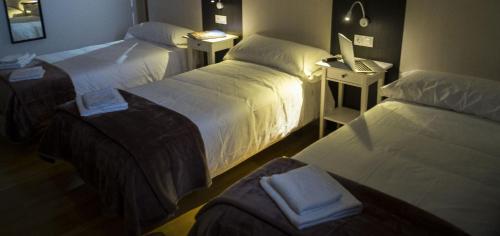 a hotel room with two beds with towels on them at Pension 23-Vinte e Tres in O Pedrouzo