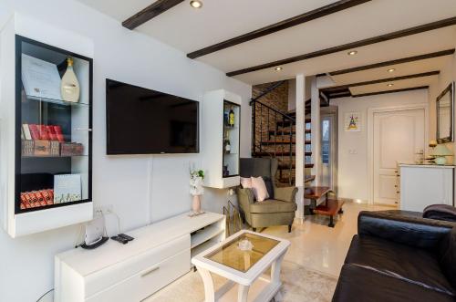 sala de estar con sofá y TV en la pared en Holiday Home Avantgarde en Dubrovnik