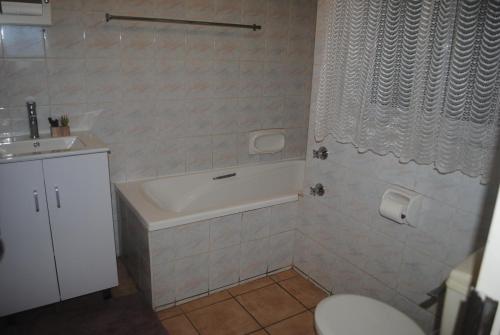 a bathroom with a tub and a toilet and a sink at 29 Adante in Kingsborough