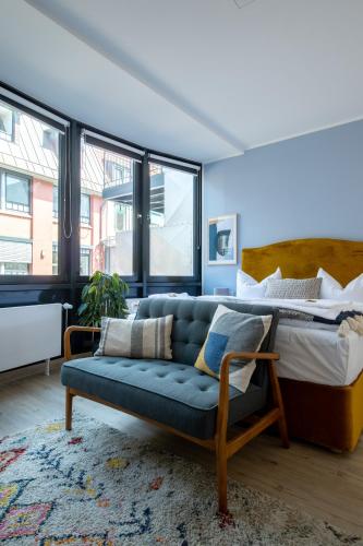 a living room with a couch and a bed at Limehome Flensburg Holm in Flensburg