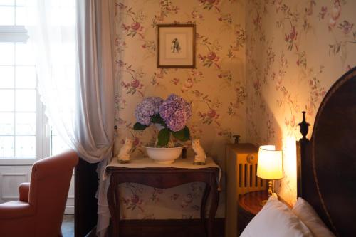 una habitación con un jarrón de flores sobre una mesa en Casa Dos Varais, Manor House en Lamego