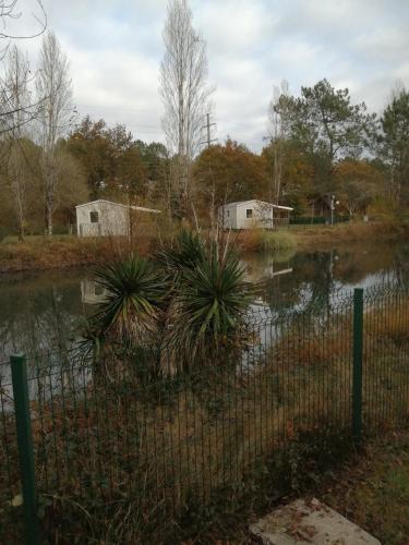 a fence in front of a body of water at Camping des Abesses in Saint-Paul-lès-Dax