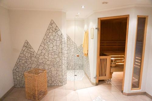 a bathroom with a shower with a geometric wall at Dorf Alm in Obergurgl