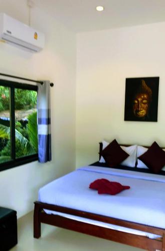 a bedroom with a bed with a mask on the wall at Daisy's 2 bedroom family home for up to 5 guests with garden & BBQ in Ko Samed