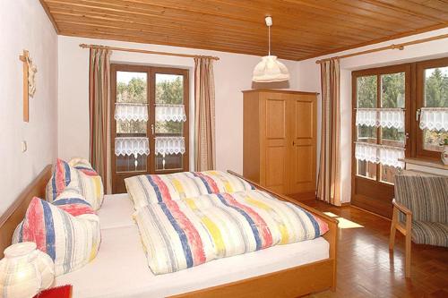a bedroom with a bed and two windows at Exenbacher Hof - Pension in Arnbruck