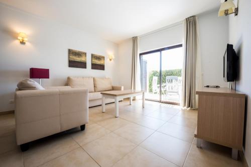 a living room with a couch and a tv at Sagres Time Apartamentos in Sagres