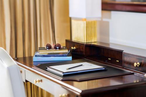 a wooden desk topped with a book and a lamp at Trump National Doral Golf Resort in Miami