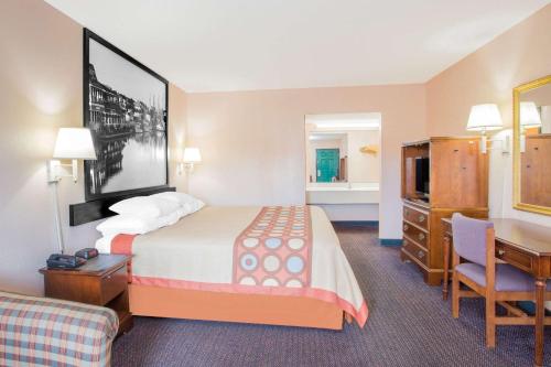 a hotel room with a bed and a desk and a room at Super 8 by Wyndham Columbia in Columbia