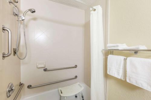 a bathroom with a shower and a toilet and towels at Super 8 by Wyndham Latham - Albany Airport in Latham