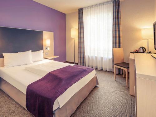 ベルリンにあるメルキュール ホテル ベルリン シティ ウェストの大きなベッドと窓が備わるホテルルームです。