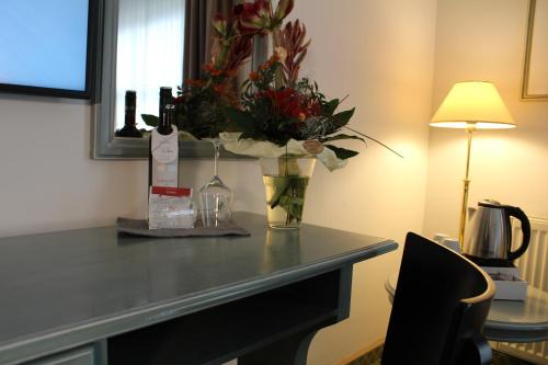 a table with a vase with flowers on it at Hotel Residenz Bad Frankenhausen in Bad Frankenhausen