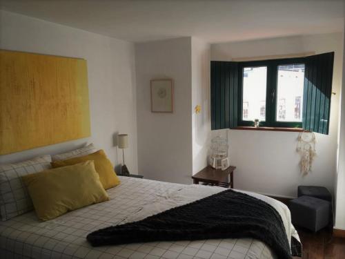 um quarto com uma cama grande e uma janela em King Garfield House - Espaço de charme em Bragança em Brangança