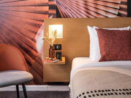 a hotel room with a bed and a chair at Novotel Paris Vaugirard Montparnasse in Paris