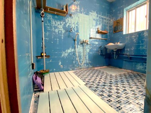 a blue bathroom with a shower and a sink at Guest House Icyaribacyode in Naha