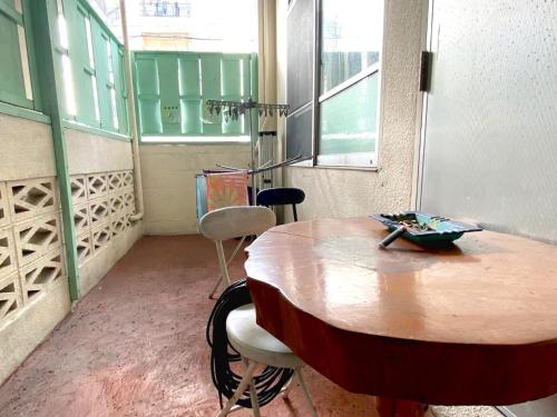 a room with a wooden table and two chairs at Guest House Icyaribacyode in Naha