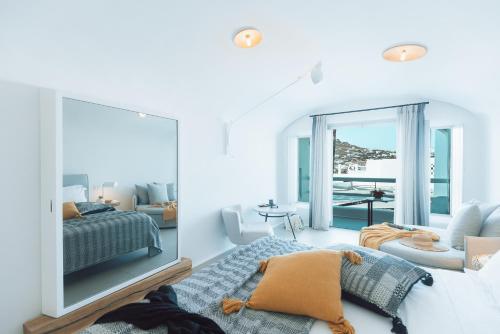a living room with a bed, couch and a window at Mykonos Blanc - Preferred Hotels & Resorts in Ornos