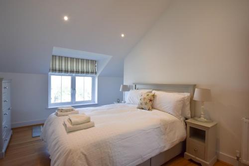 a bedroom with a large white bed with towels on it at Whispers - 4 bedroom Luxury Family Holiday Home in Salcombe (Sleeps 8) in Salcombe