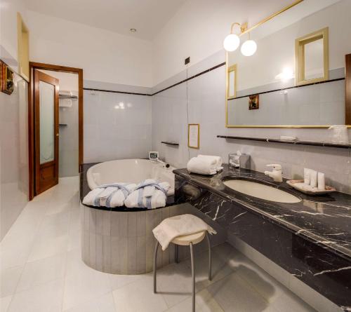 a bathroom with a tub and a sink and a mirror at Best Western Plus Hotel Villa Tacchi in Gazzo