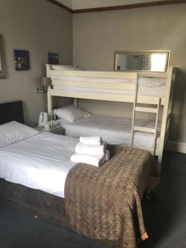 a bedroom with two bunk beds and a table at CitiHouse Aberdeen West End in Aberdeen