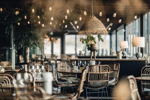 un restaurante vacío con mesas, sillas y luces en Ocean Hotel, en Falkenberg