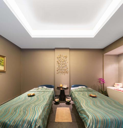 a room with two beds and a table at Radisson Collection Muscat, Hormuz Grand in Muscat