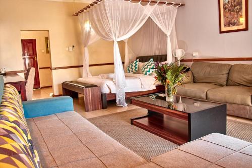 een woonkamer met een bank en een bed bij Lake Kariba Inns in Siavonga