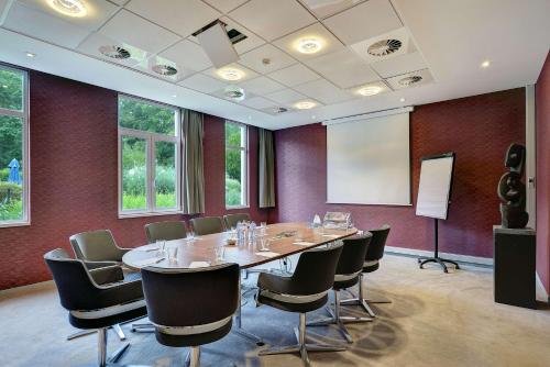 a conference room with a table and chairs and a screen at Radisson BLU Balmoral in Spa