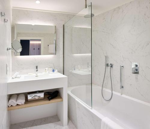 a bathroom with a tub and a sink and a shower at Radisson BLU Balmoral in Spa