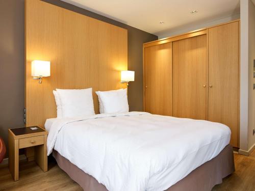 a hotel room with a large white bed and a cabinet at Radisson BLU Balmoral in Spa